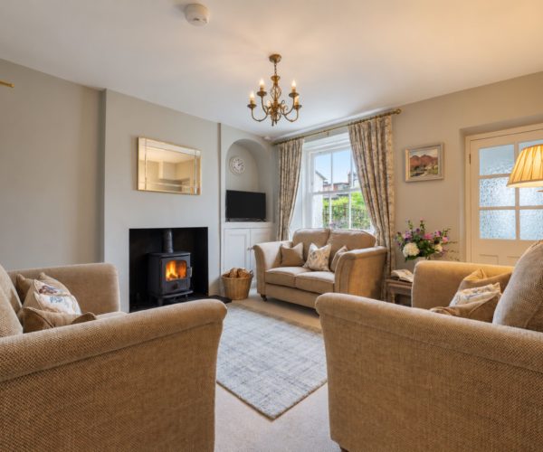 Cosy living room with log burning stove at Cornflower Cottage in Windermere